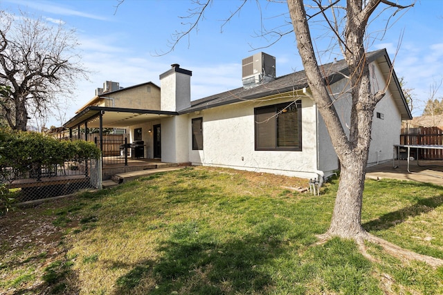 back of property with a lawn, a patio, central air condition unit, and a deck