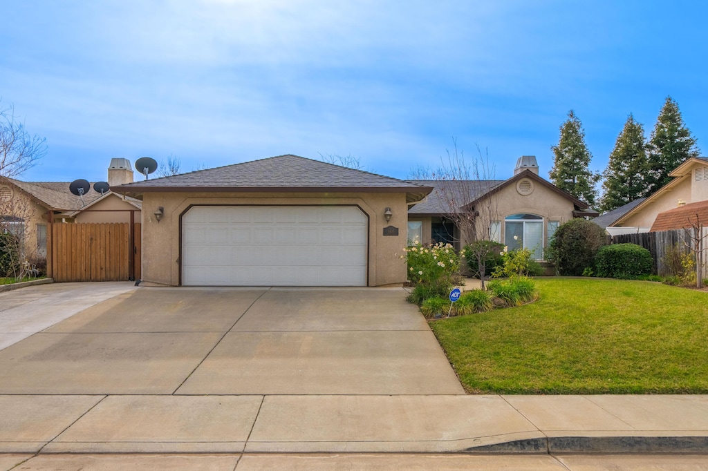 ranch-style house featuring a garage and a front lawn