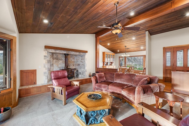 living area featuring recessed lighting, lofted ceiling, wood ceiling, a wood stove, and ceiling fan with notable chandelier