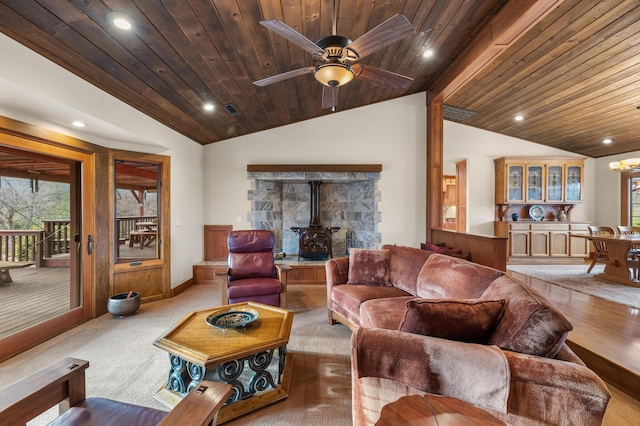 living area featuring lofted ceiling, recessed lighting, wood ceiling, a wood stove, and ceiling fan