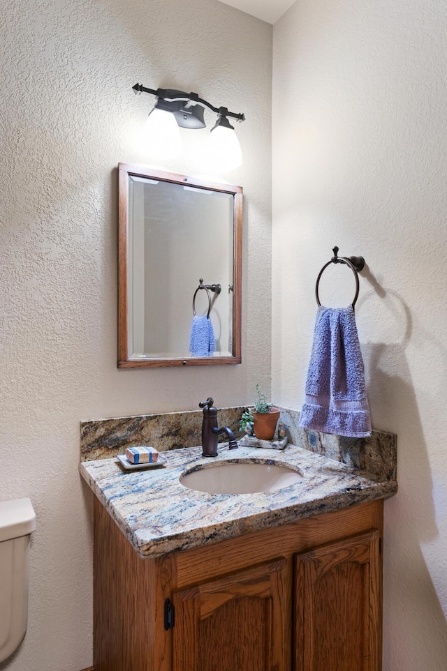 half bathroom with toilet and vanity