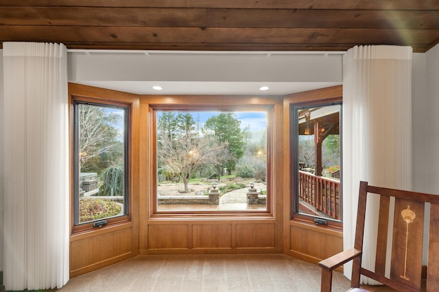 interior space featuring carpet, wooden walls, and recessed lighting