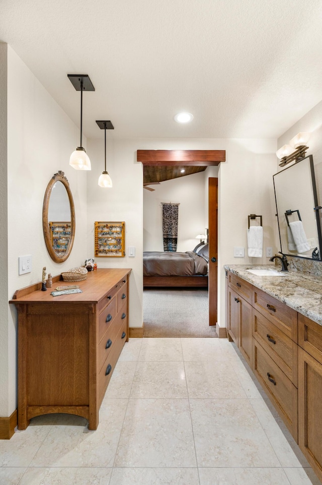 bathroom with a sink, two vanities, ensuite bath, and baseboards