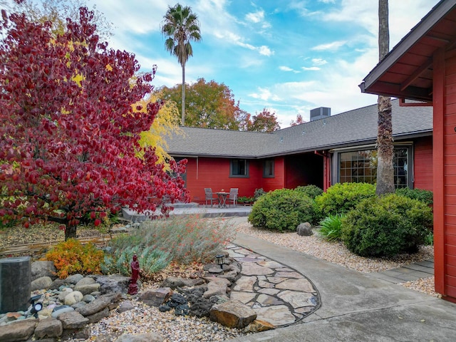 exterior space featuring a patio and roof with shingles