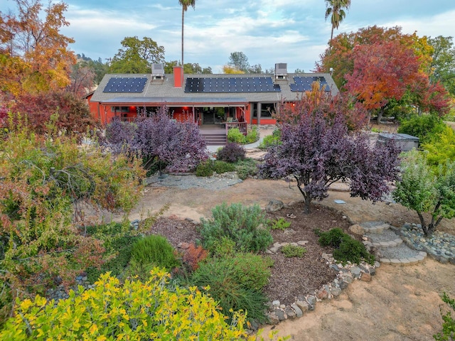 view of front of home with a chimney and solar panels