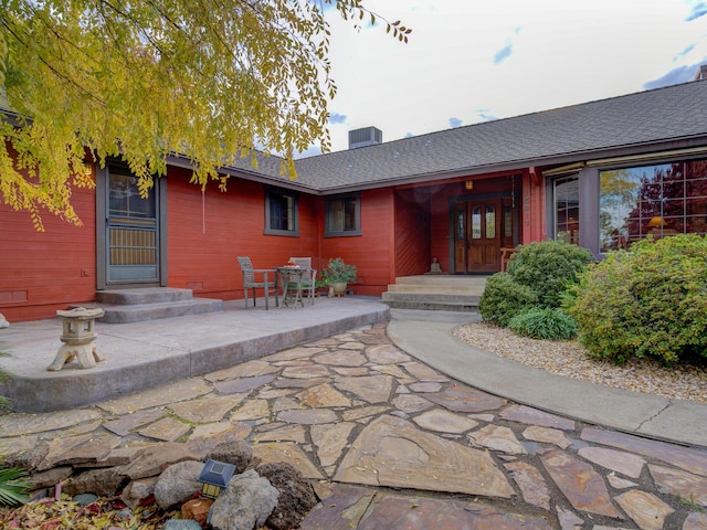 property entrance with roof with shingles