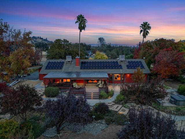 back of property at dusk featuring a chimney