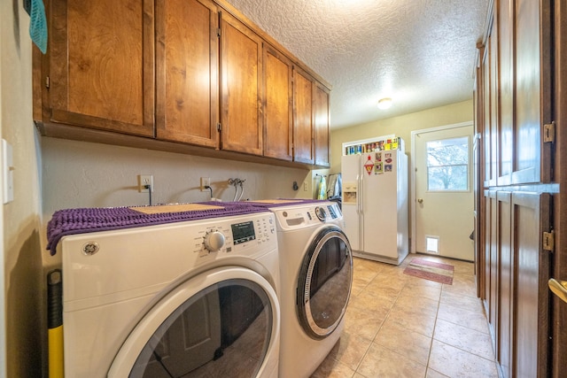 clothes washing area featuring cabinet space, light tile patterned floors, separate washer and dryer, and a textured ceiling