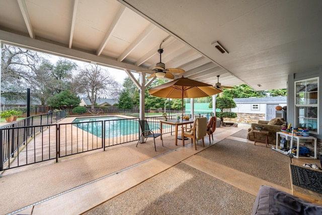 view of patio featuring a fenced in pool, an outbuilding, a fenced backyard, and a ceiling fan