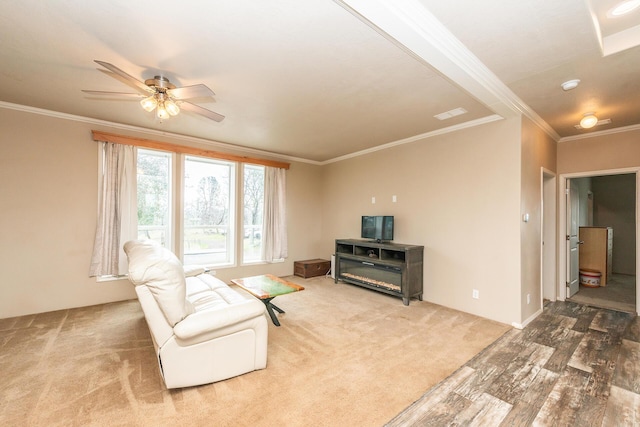 living room with ceiling fan, carpet flooring, and crown molding