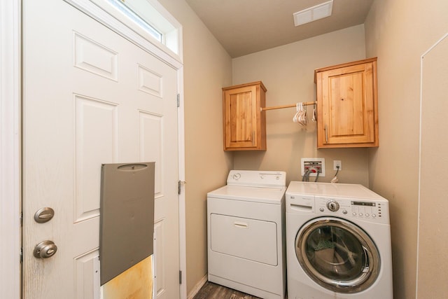 washroom featuring cabinets and washer and clothes dryer