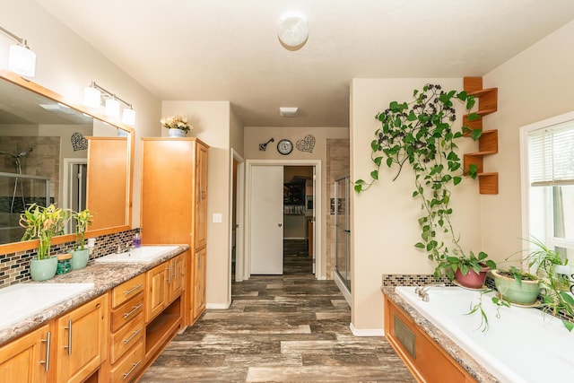 bathroom with hardwood / wood-style floors, backsplash, vanity, and shower with separate bathtub