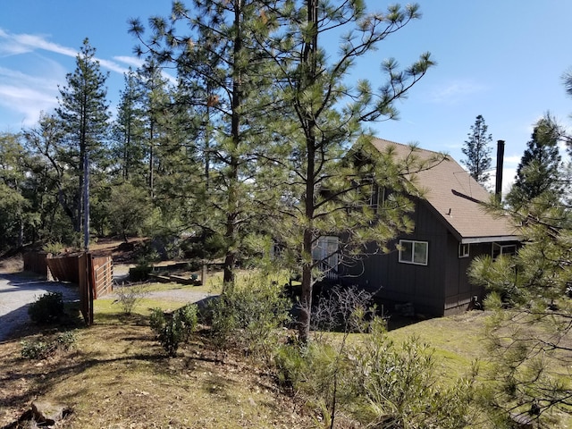 view of side of property featuring roof with shingles