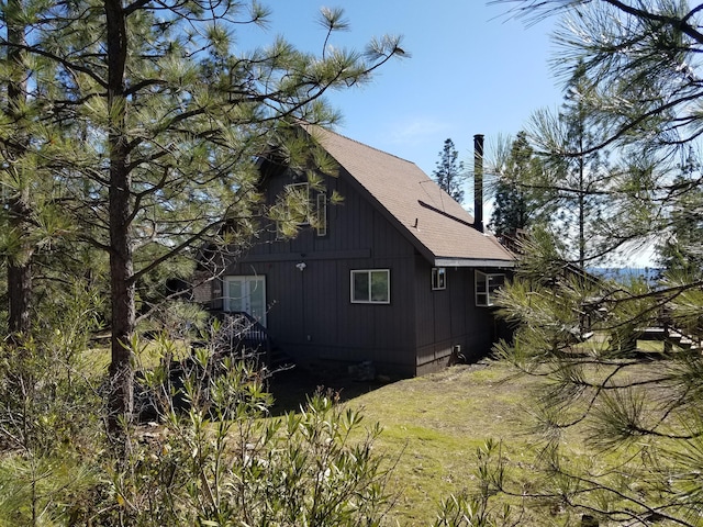 view of property exterior with roof with shingles