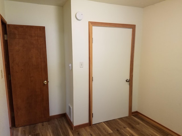 unfurnished bedroom featuring visible vents, baseboards, and wood finished floors
