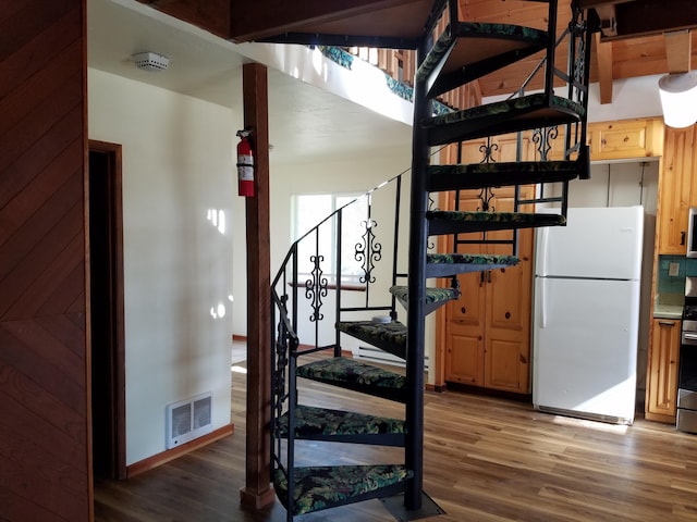 staircase featuring baseboards, visible vents, and wood finished floors