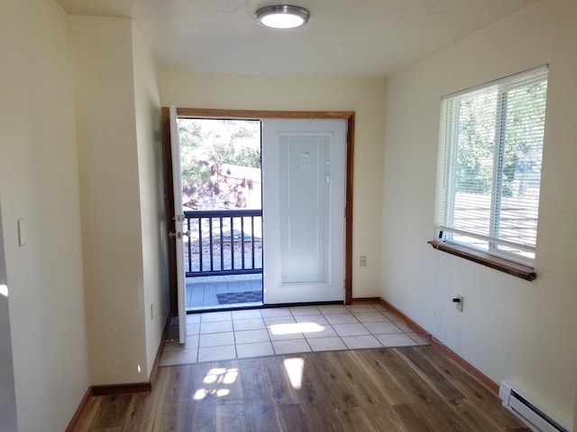entryway featuring baseboards, baseboard heating, and wood finished floors