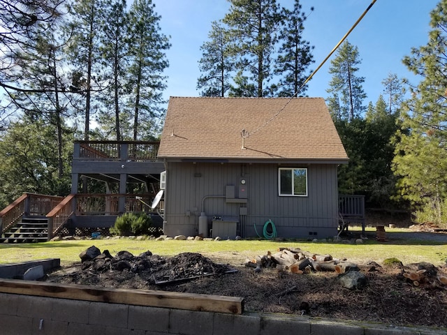 back of house featuring roof with shingles, a deck, crawl space, and a yard