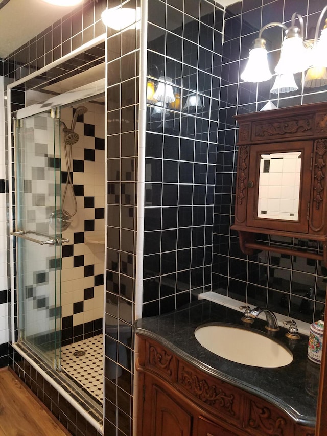 bathroom with decorative backsplash, vanity, wood finished floors, and a shower stall
