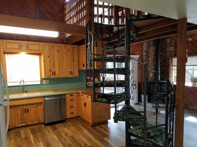 kitchen featuring stainless steel dishwasher, light wood finished floors, a sink, and freestanding refrigerator