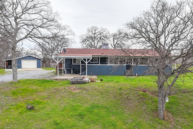 view of front facade with a garage, an outbuilding, and a front lawn