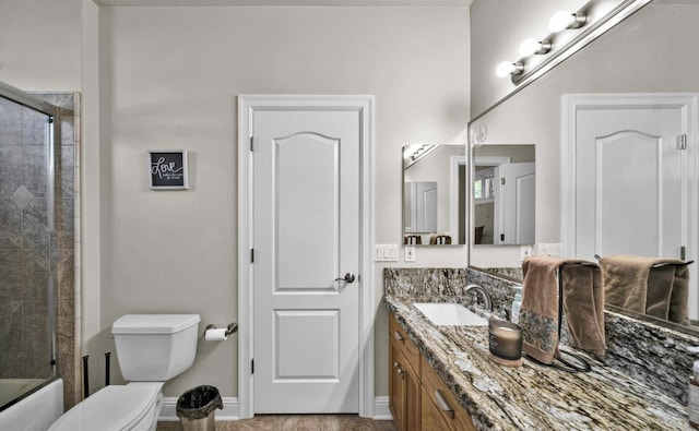 full bathroom featuring toilet, vanity, and combined bath / shower with glass door