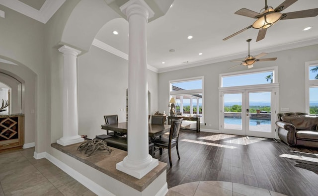 dining area with decorative columns, ornamental molding, and a towering ceiling