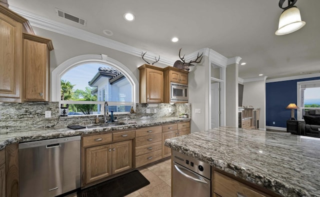 kitchen with appliances with stainless steel finishes, sink, stone countertops, and light tile patterned floors