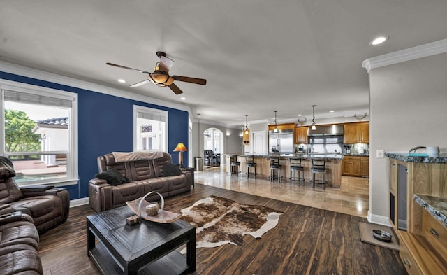 living room featuring ceiling fan, dark wood-type flooring, and crown molding