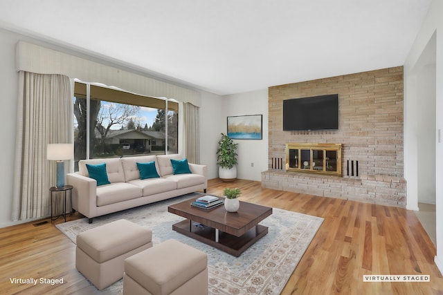 living room with a large fireplace and hardwood / wood-style flooring