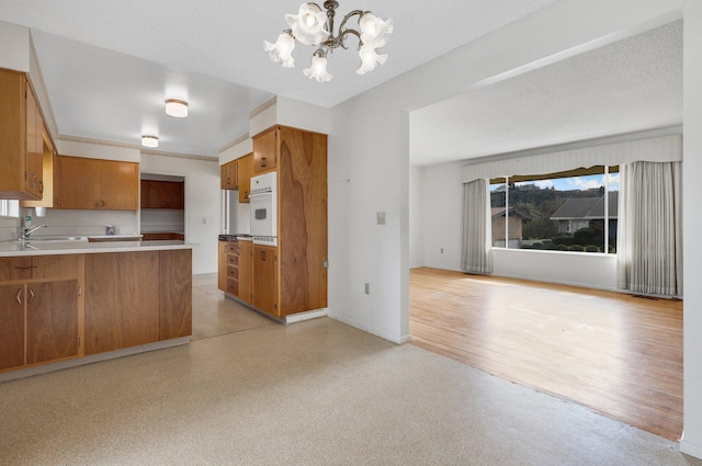 kitchen featuring hanging light fixtures, a wealth of natural light, a textured ceiling, and white oven