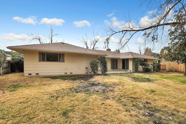 rear view of property with a patio and a lawn