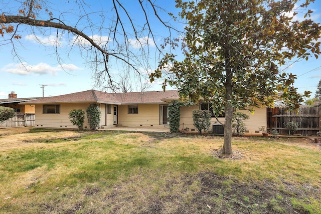 rear view of property featuring central AC unit, a lawn, and a patio area