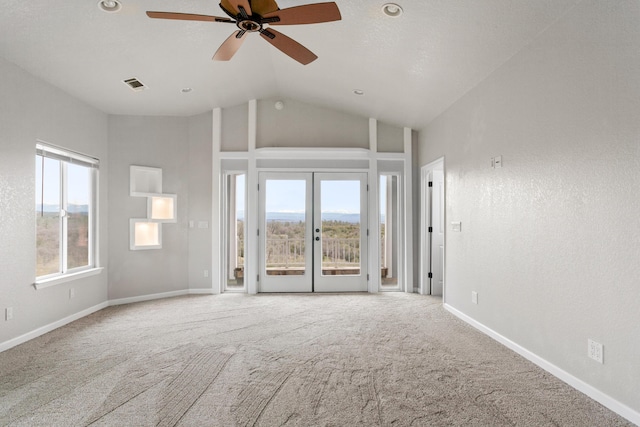 carpeted spare room featuring ceiling fan, high vaulted ceiling, and french doors