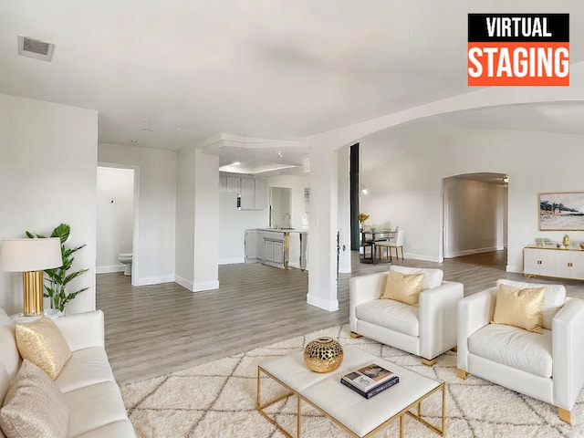 living room with hardwood / wood-style floors and sink