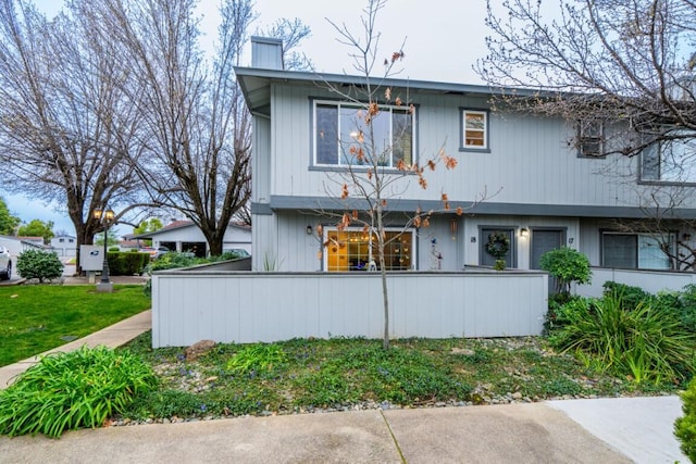 view of front of house with a fenced front yard and a chimney