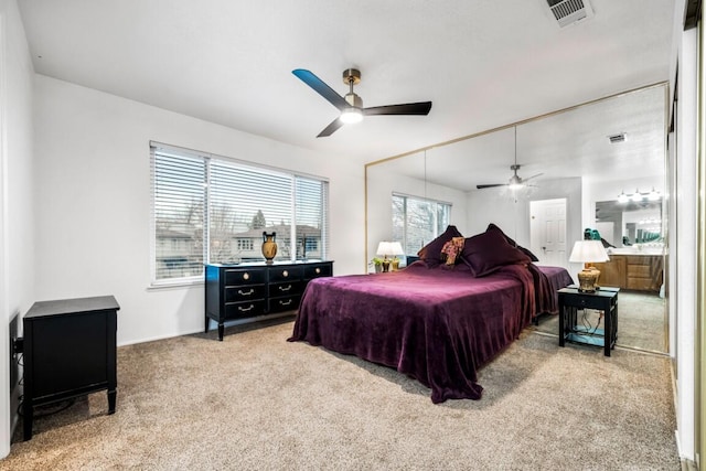 bedroom featuring ceiling fan, visible vents, and light colored carpet