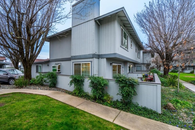 view of side of property with fence and a lawn