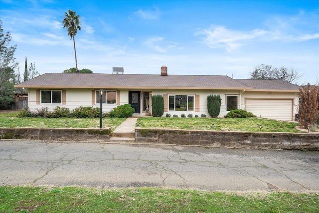 ranch-style house with a garage, a chimney, a front lawn, and stucco siding