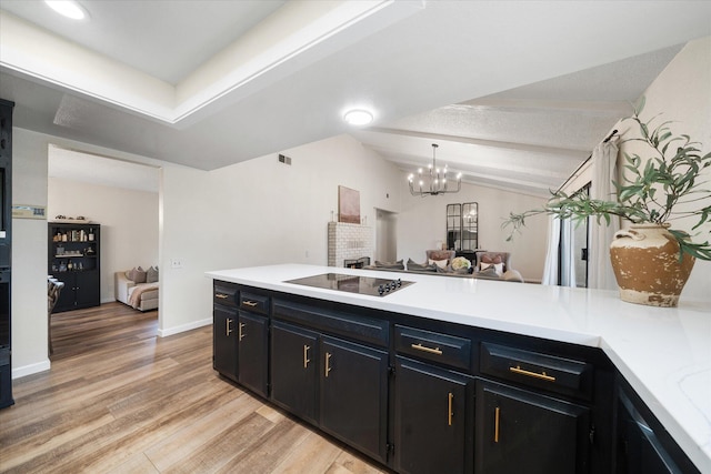 kitchen featuring light countertops, lofted ceiling with beams, light wood-style floors, open floor plan, and black electric cooktop