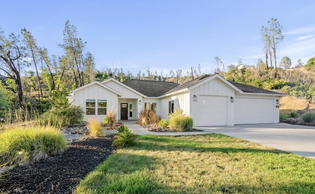 view of front of property with board and batten siding, a front yard, concrete driveway, and an attached garage