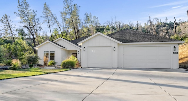 view of front of home with driveway, a garage, board and batten siding, and roof with shingles