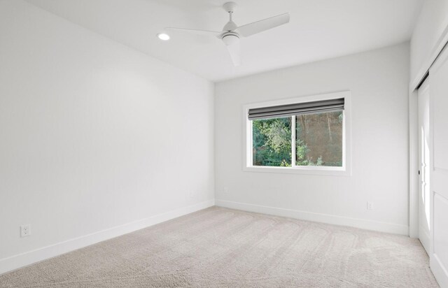 unfurnished room featuring light carpet, recessed lighting, a ceiling fan, and baseboards