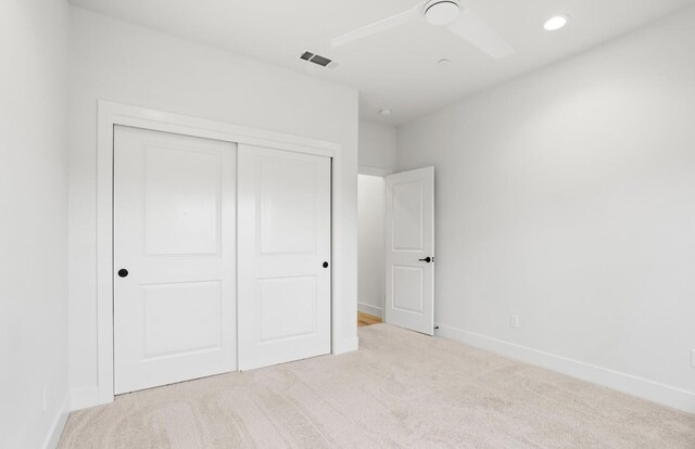 unfurnished bedroom featuring recessed lighting, light colored carpet, visible vents, baseboards, and a closet