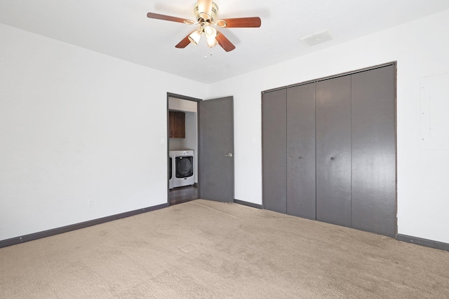 unfurnished bedroom featuring visible vents, carpet flooring, washer / dryer, and baseboards