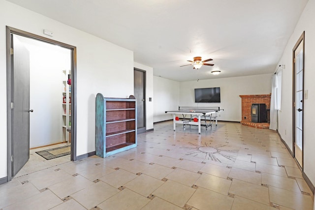 interior space featuring a fireplace, a ceiling fan, and baseboards