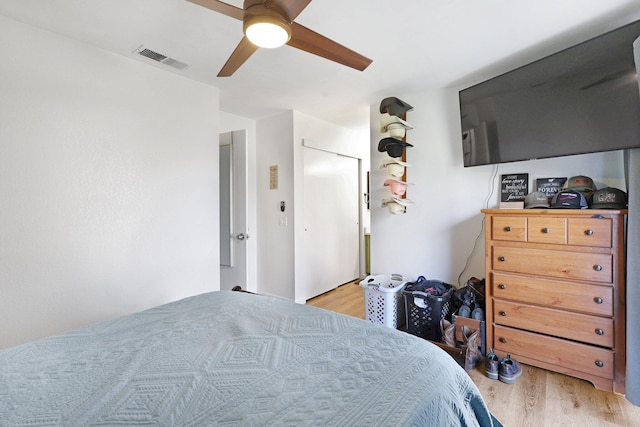 bedroom featuring a ceiling fan, visible vents, and light wood-style floors