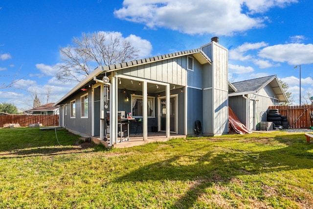 back of house featuring a lawn and fence