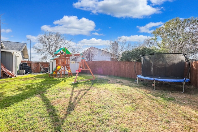 view of yard featuring a trampoline, a playground, a fenced backyard, and a storage shed