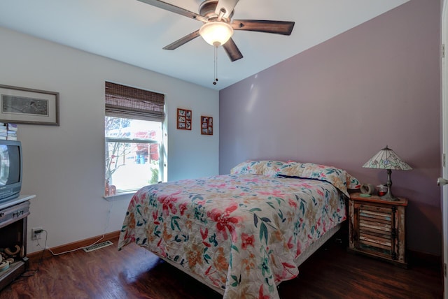 bedroom featuring dark wood-type flooring, visible vents, baseboards, and a ceiling fan